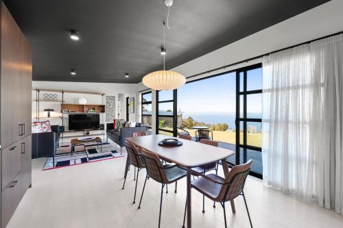 a kitchen and dining room with a table and chairs at The Outlook on Mount Louis - 1 Bedroom - Stunning Views in Tinderbox