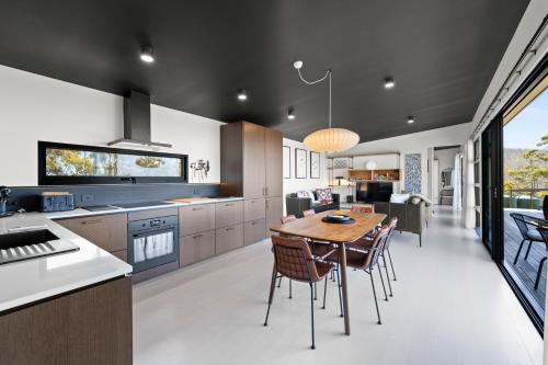 a kitchen and dining room with a table and chairs at The Outlook on Mount Louis - 1 Bedroom - Stunning Views in Tinderbox