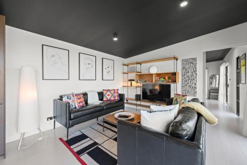 a living room with a couch and a table at The Outlook on Mount Louis - 1 Bedroom - Stunning Views in Tinderbox