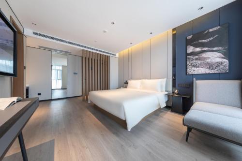 a hotel room with a bed and a couch at Atour Hotel Chengdu Sichuan Normal University in Chengdu