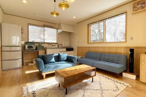 a living room with two blue couches and a table at コーボ in Yamanakako