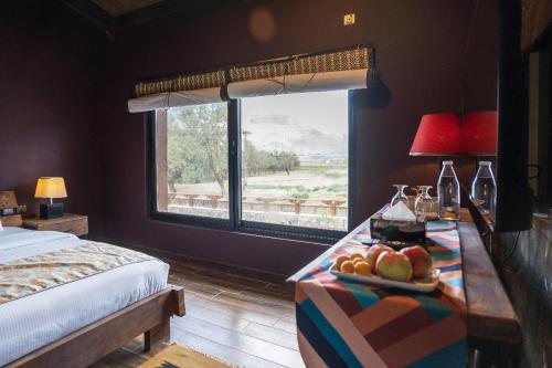 a bedroom with a bed and a table with fruit on it at PC Legacy Skardu in Skardu