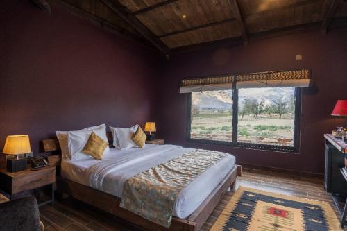 a bedroom with a large bed with a large window at PC Legacy Skardu in Skardu
