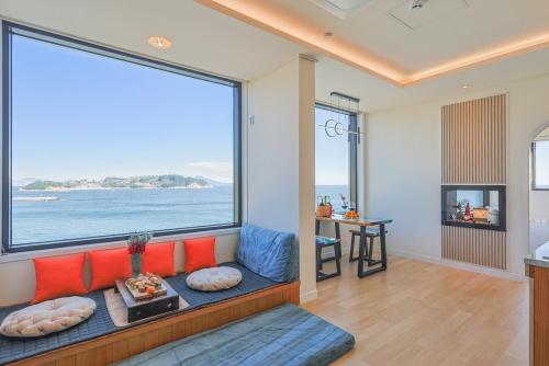 ein Wohnzimmer mit Couch und großem Fenster in der Unterkunft Geoje Dream Angel Pool Villa in Geoje