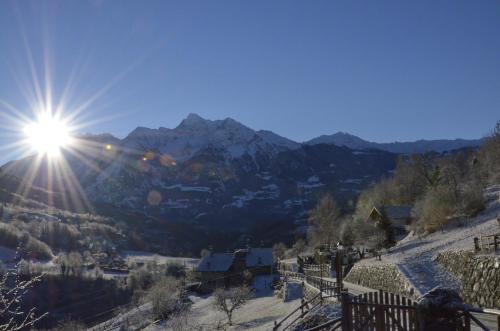 a sun is shining on a snow covered mountain at La Fattoria di Roven in Gignod