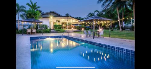 a swimming pool in front of a house at Siam Country Resort in Nong Prue