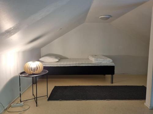 a small bed in a room with a table at Huvila saunalla ja paljulla Korpilammen rannalla in Espoo