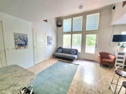 a living room with a blue couch and a table at Huvila saunalla ja paljulla Korpilammen rannalla in Espoo