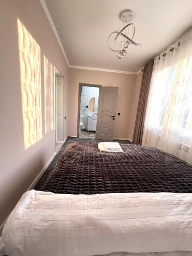 a bedroom with a large bed in a room at MARAL GuestHouse in Karakol