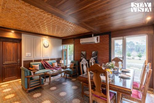 a living room with a table and chairs at StayVista at Khwab Villa with Lawn, BBQ in Srinagar