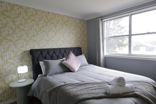 a bedroom with a bed with two towels on it at Country 4-Bed Homestead with Games Room & Views in Tenterfield