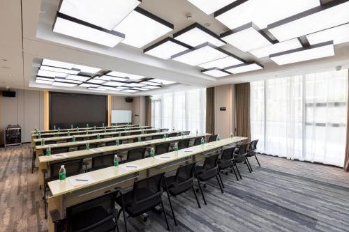 a classroom with tables and chairs in a room with windows at Atour Hotel Chengdu Sichuan Normal University in Chengdu
