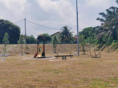 a park with a bench and a playground at Nieo Village 1 in Port Dickson