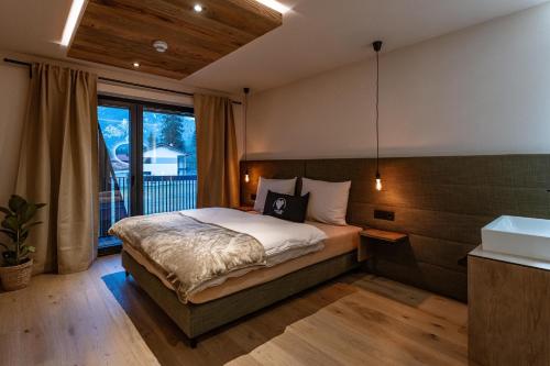 a bedroom with a bed and a large window at Jaggling Appartements in Sankt Ulrich am Pillersee