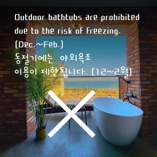 a bathroom with a bath tub and a window at Browndot Terrace Pohang Passenger Terminal in Pohang