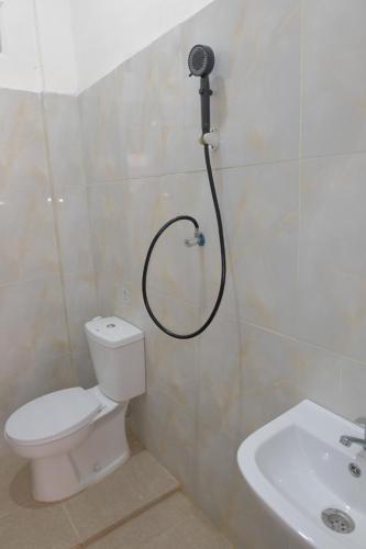a shower in a bathroom with a toilet and a sink at BI Hotel Kisaran in Kisaran