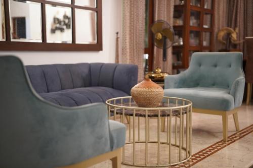 a living room with two blue chairs and a table at Sandy Bliss Villa in Sri Jayewardenepura Kotte