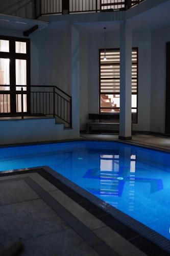 a swimming pool with blue water in a building at Sandy Bliss Villa in Sri Jayewardenepura Kotte