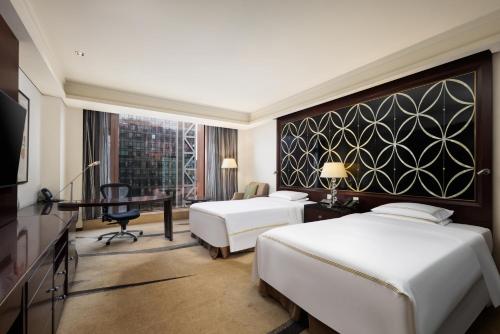 a hotel room with two beds and a desk at Fairmont Beijing - 20 minutes to Forbidden City by metro in Beijing