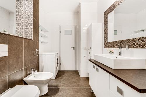 a white bathroom with a sink and a toilet at ARI - ARED Luxurious Apartments with Balcony & Free Parking in Arad