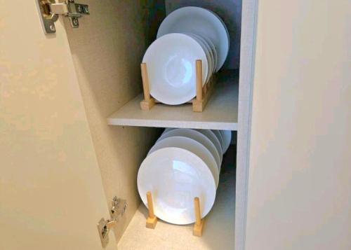 a cupboard with plates and bowls in it at Brand New Residence with Family in Busan