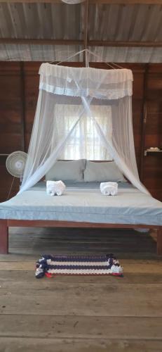 a bed with a canopy with two towels on it at Sambath Sakseth Bungalow in Koh Rong Island