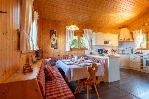 une salle à manger avec une table et une cuisine dans l'établissement Chalet avec sauna entre Lac Leman, Montagnes et Golf - Le Cocon du Lac Léman, à Évian-les-Bains