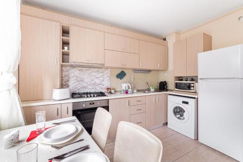 a kitchen with wooden cabinets and a white refrigerator at ARI - ARED Luxurious Apartments with Balcony & Free Parking in Arad