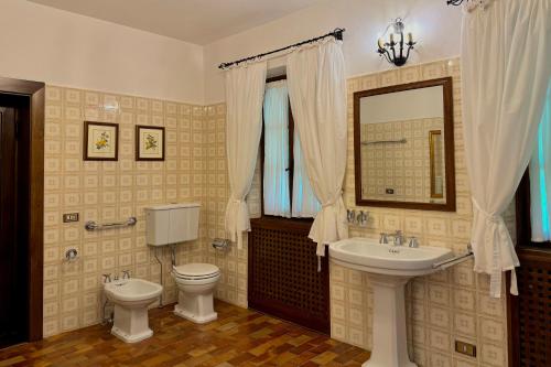 a bathroom with a sink and a toilet and a mirror at Chalet Miralago in Plesio