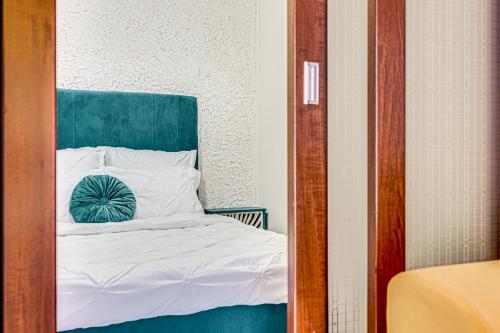 a bedroom with a bed with a green headboard at ARI - ARED Luxurious Apartments with Balcony & Free Parking in Arad