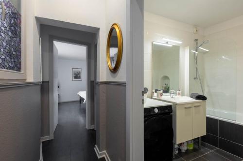 une salle de bain avec un lavabo et un miroir dans l'établissement La Kokot d'Alsace 2P centrę ville proximité Cathédrale, à Strasbourg