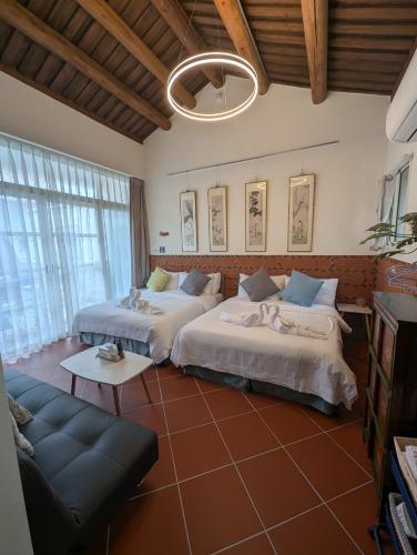 a living room with two beds and a couch at Lanshe Gate in Chung-lan