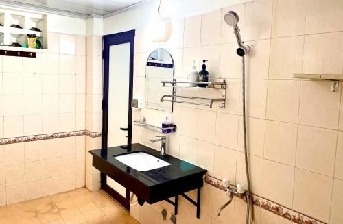 a bathroom with a black sink and a shower at Lee Homestay in Hanoi