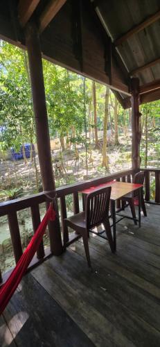 a wooden table and chairs on a porch at Sambath Sakseth Bungalow in Koh Rong Island