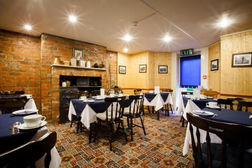 a restaurant with tables and chairs and a brick wall at The Camberley in Harrogate
