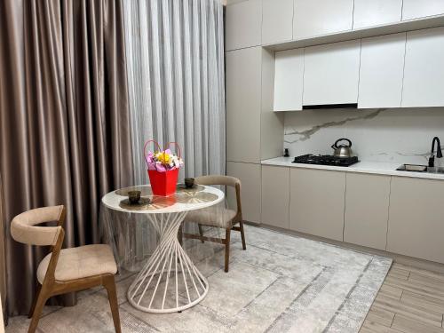 una cucina con un tavolo con un vaso di fiori sopra di ЖК Керуен Сарай 4 a Türkistan