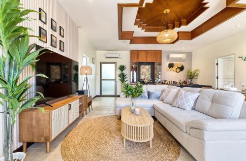 a living room with a white couch and a table at Cozy Asian house pool villa Pattaya 4 bedroom,Pet friendly in Jomtien Beach