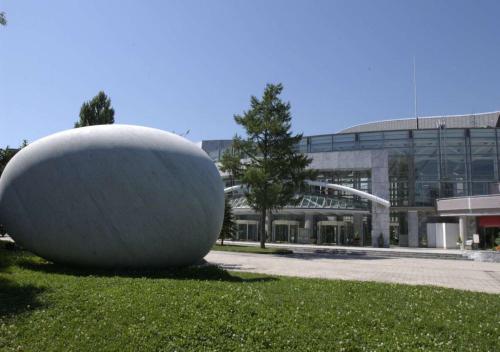 a large white object sitting in the grass in front of a building at Business Inn Norte in Sapporo