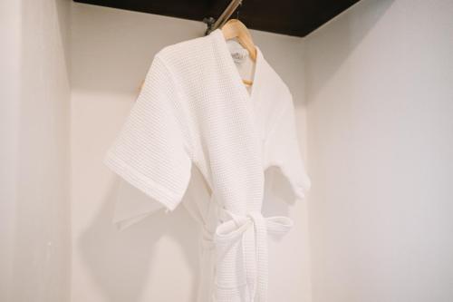 a white robe hanging on a wall at The Courtyard Chiangrai in Chiang Rai