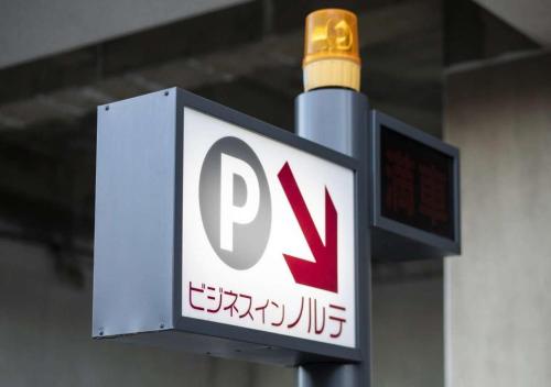 a sign on a pole with a pay sign on it at Business Inn Norte in Sapporo