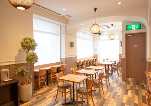 a row of tables and chairs in a restaurant at Business Inn Norte in Sapporo