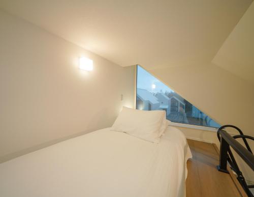 a bedroom with a white bed and a window at Niseko White Villas I in Kombu
