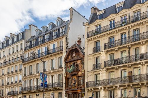 un groupe de bâtiments dans une rue avec un bâtiment dans l'établissement Sweett - Rue Saint-Lazare, à Paris