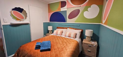a bedroom with a bed and a colorful wall at Arty Apartments in Tauranga