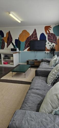 a living room with two beds and a tv at Arty Apartments in Tauranga