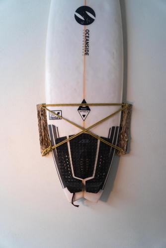 a surfboard is hanging on a wall at The Cafecito Surfhouse - Santa Teresa in Santa Teresa Beach