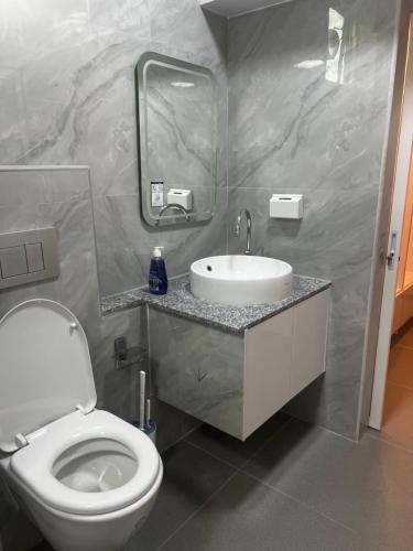 a bathroom with a white toilet and a sink at AA inn in Hulhumale