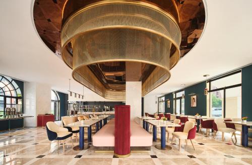 a restaurant with tables and chairs and a large ceiling at The Stage Shanghai in Shanghai