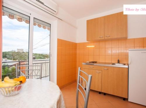 une cuisine avec une table avec un bol de fruits dessus dans l'établissement Apartments Bionda, à Novi Vinodolski