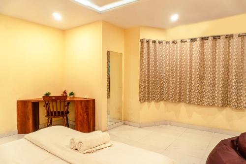 a bedroom with a desk and a bed and a chair at Sea La Vie Andaman in Haddo